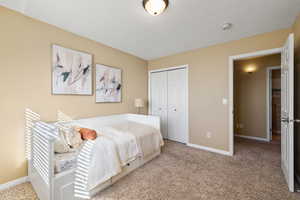 Bedroom featuring carpet floors, baseboards, and a closet