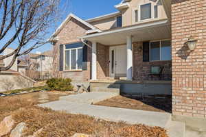 View of front of property with covered porch and brick siding