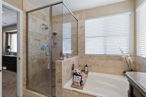 Bathroom featuring a stall shower, a textured ceiling, and a bath