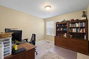 Office with carpet, a textured ceiling, and baseboards