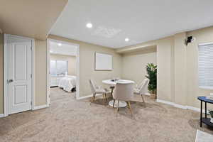 Carpeted dining area with recessed lighting and baseboards