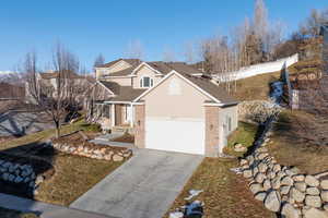 Traditional-style home featuring driveway, fence, and stucco siding