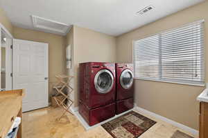 Laundry room featuring laundry area, visible vents, baseboards, washer and dryer, and attic access