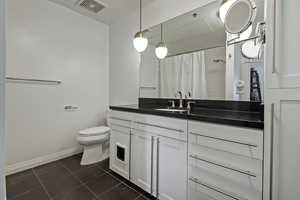 Bathroom with visible vents, a shower with shower curtain, toilet, baseboards, and tile patterned floors