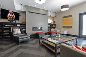 Living room with a fireplace, baseboards, and recessed lighting