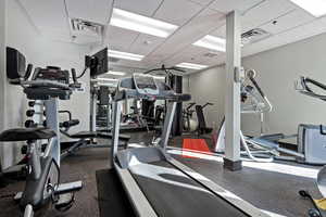 Workout area featuring a drop ceiling and visible vents