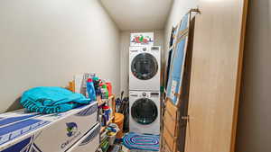 Laundry room featuring stacked washer and clothes dryer and laundry area