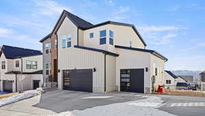 View of front facade with concrete driveway, board and batten siding, and an attached garage