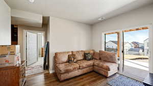 Living area featuring a textured ceiling, dark wood-type flooring, visible vents, and baseboards