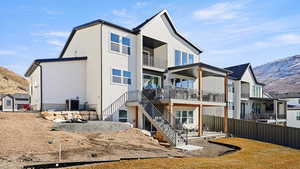 Back of house featuring a patio, a mountain view, a balcony, central AC, and fence