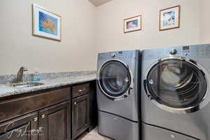 Laundry area with light carpet, washing machine and dryer, a sink, and cabinet space