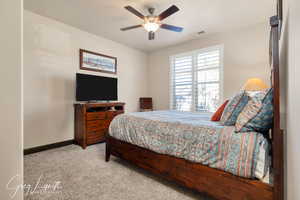 Bedroom #2 with light carpet, a ceiling fan, visible vents, and baseboards