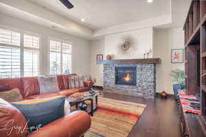 Living area with baseboards, visible vents, dark wood-style flooring, a fireplace, and recessed lighting