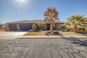 View of front of house featuring an attached garage, stone siding, a tiled roof, driveway, and stucco siding