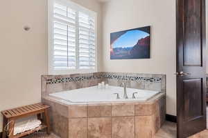 Spacious owners suite with full bath, featuring double vanity, soaker tub, and tiled shower