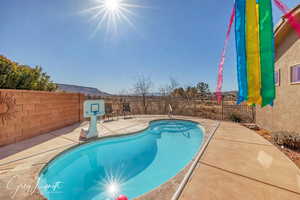 View of pool featuring a patio area, a fenced backyard, and a fenced in pool