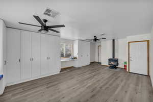 Unfurnished living room with light wood-type flooring, visible vents, and a ceiling fan