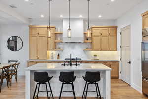 Kitchen featuring visible vents, light wood-style flooring, extractor fan, light brown cabinetry, and open shelves