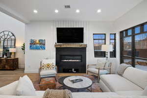 Living area featuring baseboards, visible vents, wood finished floors, and recessed lighting