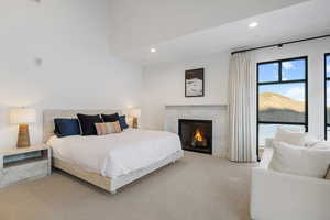 Bedroom with light carpet, a premium fireplace, and recessed lighting