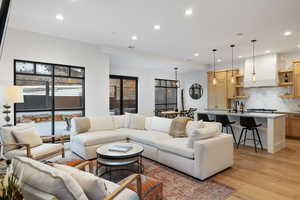 Living room featuring light wood finished floors, visible vents, and recessed lighting