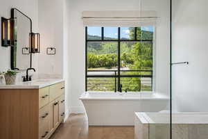 Full bath featuring vanity, a freestanding tub, and tile patterned flooring