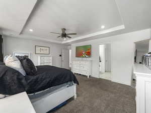 Carpeted bedroom with baseboards, a raised ceiling, a ceiling fan, and recessed lighting