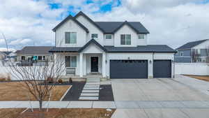 Modern inspired farmhouse featuring a garage, a shingled roof, concrete driveway, fence, and board and batten siding