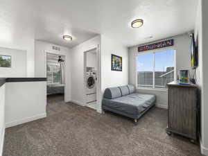 Carpeted bedroom with washer / dryer, multiple windows, and visible vents