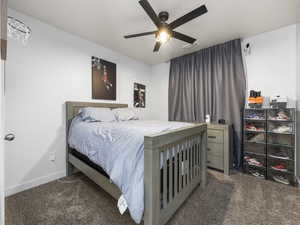 Carpeted bedroom featuring a ceiling fan, visible vents, and baseboards