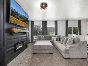 Carpeted living area with a healthy amount of sunlight and a fireplace