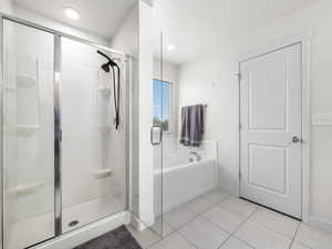 Full bathroom featuring baseboards, a shower stall, a bath, and tile patterned floors