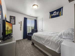 Bedroom with visible vents, dark carpet, and baseboards