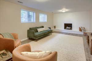 Living room with light hardwood / wood-style floors and a brick fireplace