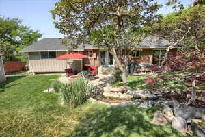 Back of property featuring a lawn and a patio