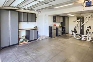 Garage featuring a garage door opener and stainless steel refrigerator