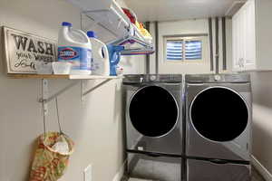 Laundry area with independent washer and dryer and cabinets