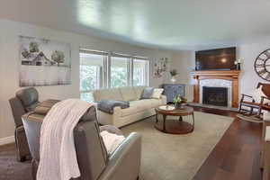 Living room featuring a tiled fireplace and hardwood / wood-style flooring