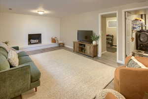 Living room featuring washer / clothes dryer, light hardwood / wood-style flooring, and a brick fireplace