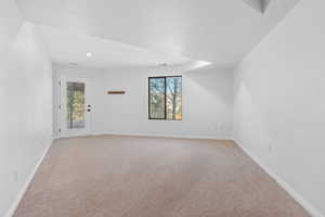 Empty room featuring a healthy amount of sunlight, baseboards, and light colored carpet