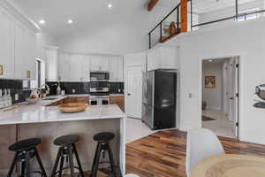 Kitchen featuring a peninsula, white cabinetry, appliances with stainless steel finishes, and a sink