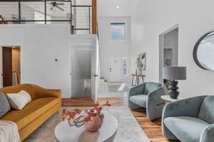 Living area with a towering ceiling and wood finished floors