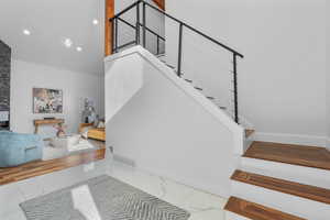 Stairs with marble finish floor, recessed lighting, visible vents, and baseboards