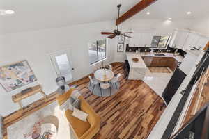 Living area featuring vaulted ceiling with beams, ceiling fan, light wood-style flooring, recessed lighting, and baseboards