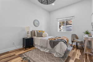 Bedroom with baseboards, wood finished floors, and recessed lighting