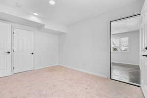 Unfurnished bedroom featuring carpet, baseboards, and recessed lighting