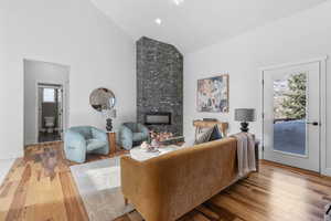 Living room featuring hardwood / wood-style flooring, a large fireplace, and a wealth of natural light