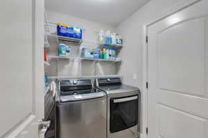 Laundry room with laundry area and washer and clothes dryer