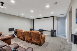 Home theater featuring carpet, visible vents, baseboards, and recessed lighting