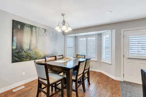 Dining room with baseboards, visible vents, and wood finished floors